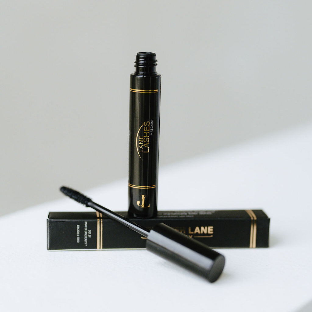 Black Lane Lashes mascara with applicator and packaging on a white surface