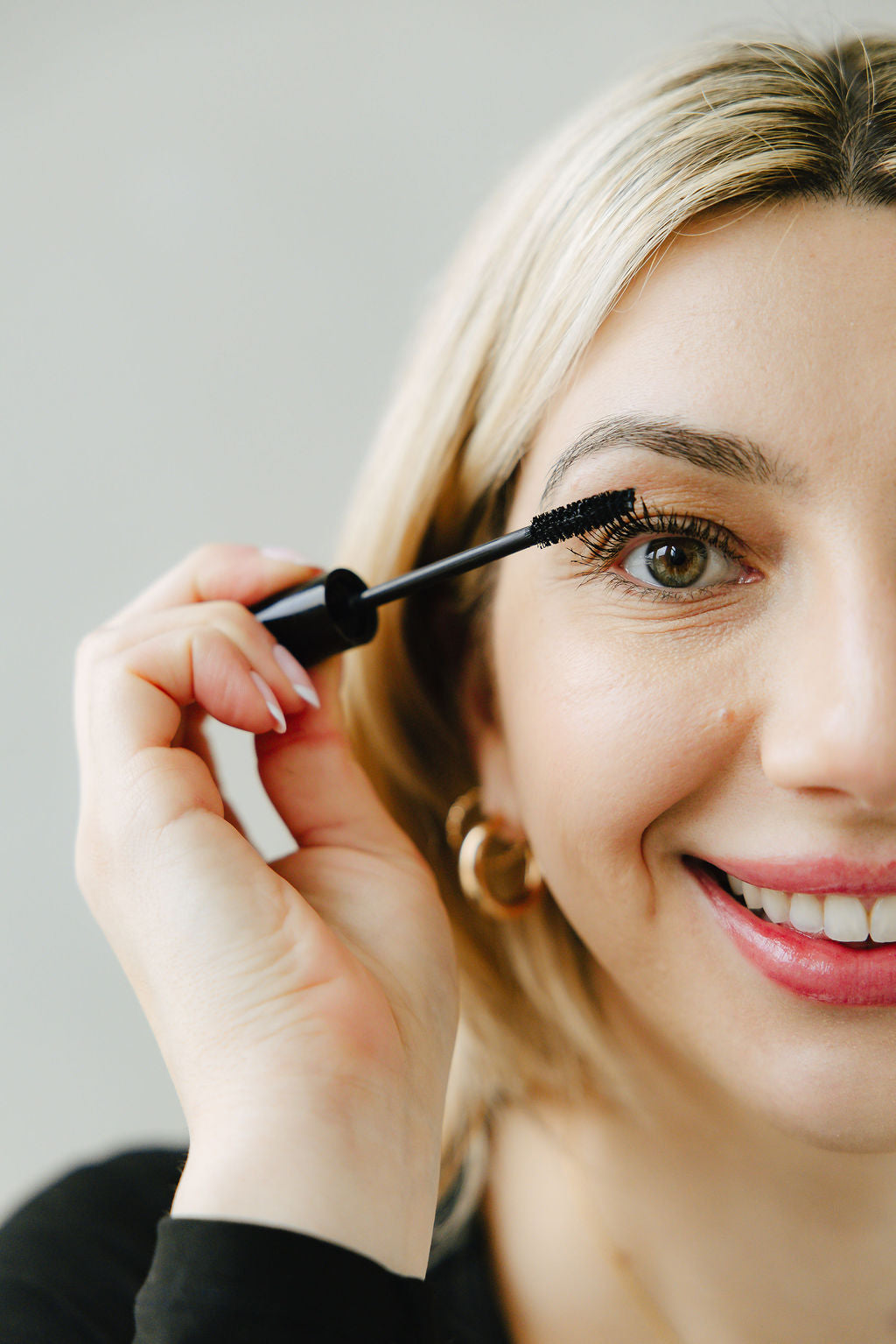 Blonde woman with fair skin applying Lane Lashes Mascara