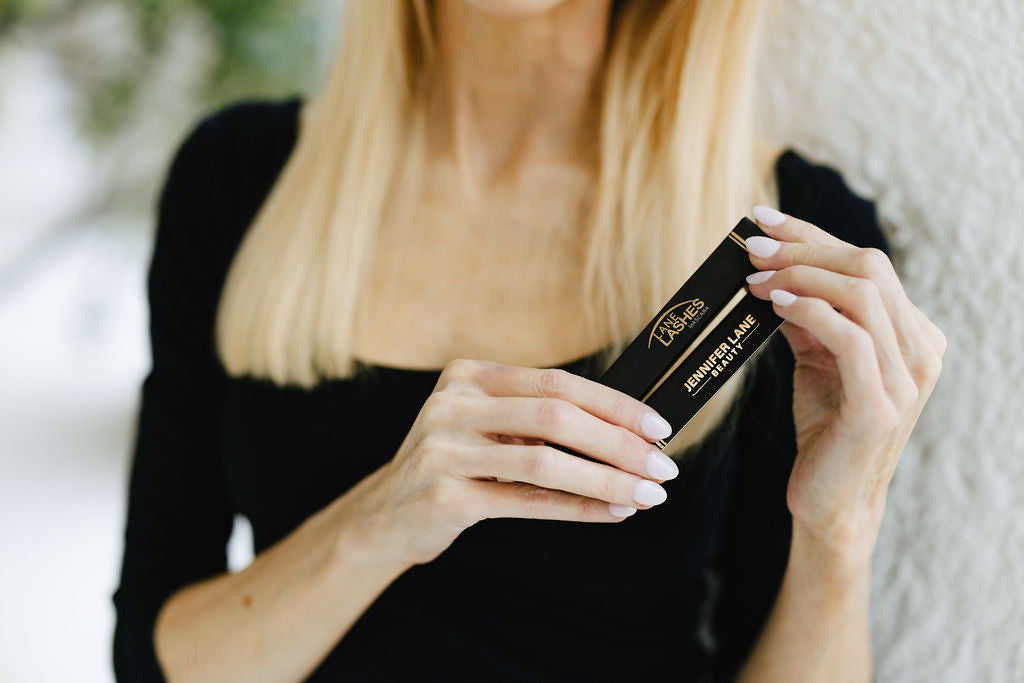 Founder Jennifer Lane holding two Lane Lashes Mascara boxes 