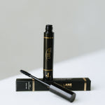 Black, highly pigmented Lane Lashes Mascara with applicator and packaging on a white surface