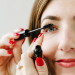 Woman applying Lane Lashes mascara with a close-up focus on her eye and hands.