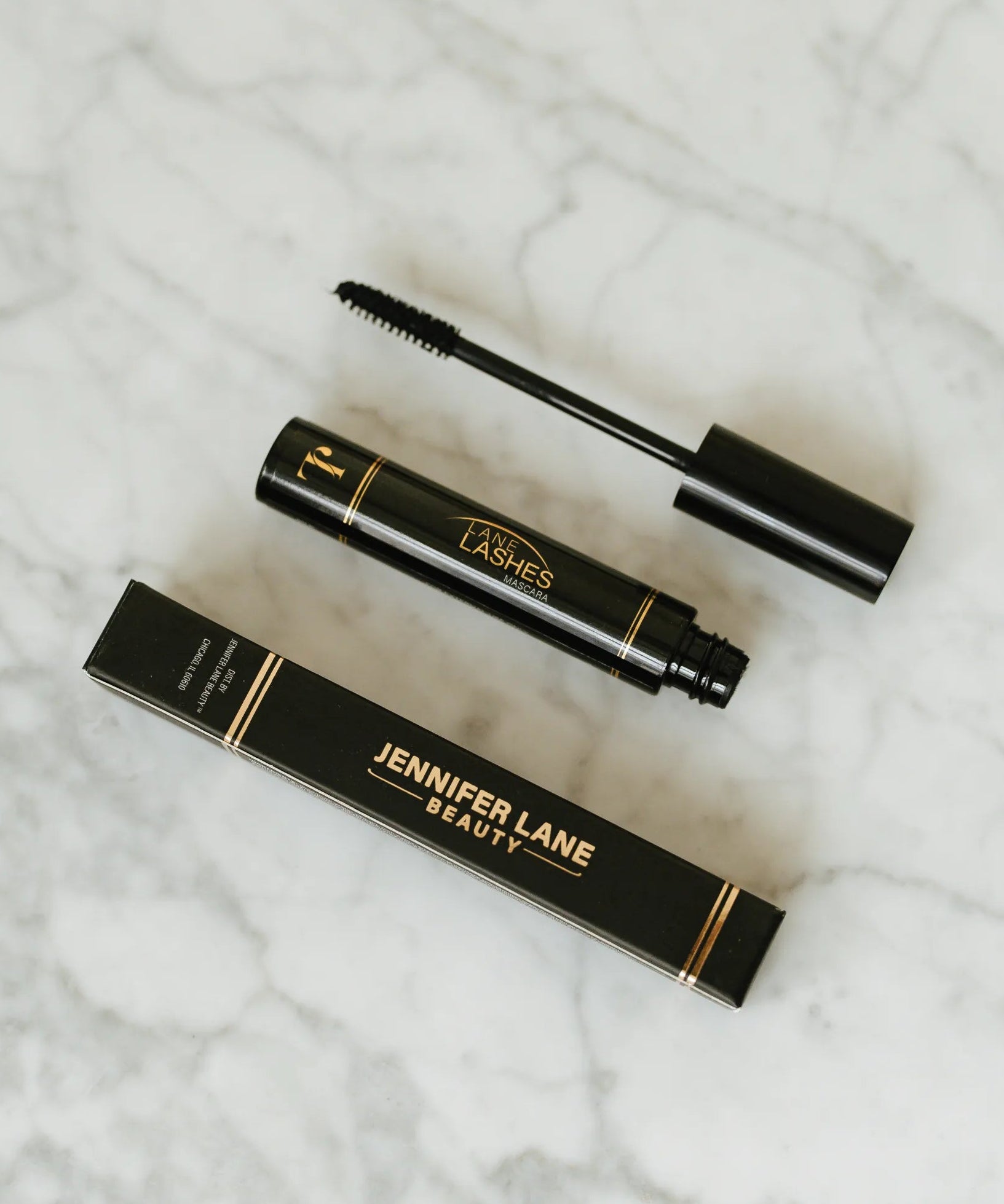 Jennifer Lane Beauty's Lane Lashes mascara on a white marble surface