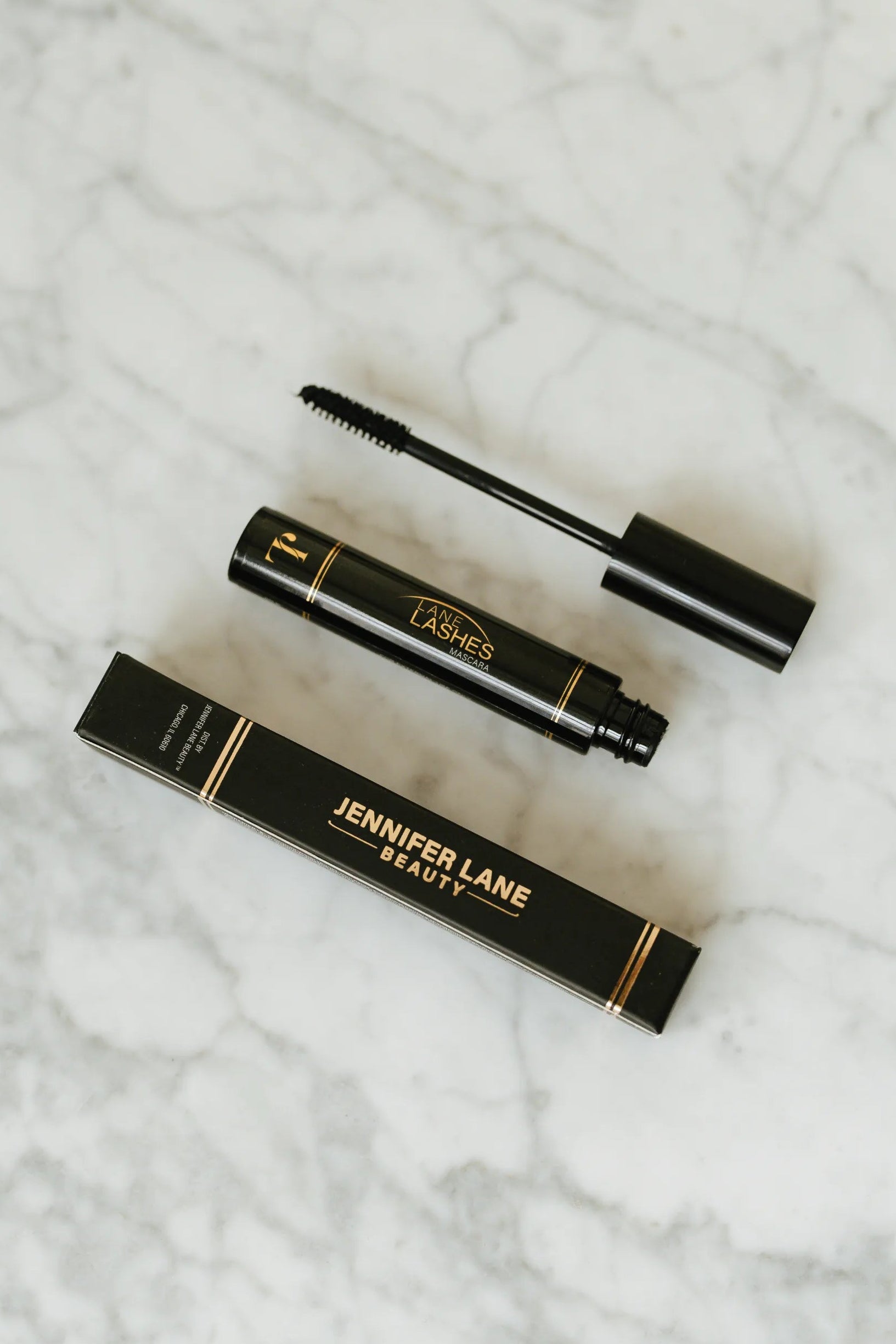 Jennifer Lane Beauty's Lane Lashes mascara on a white marble surface