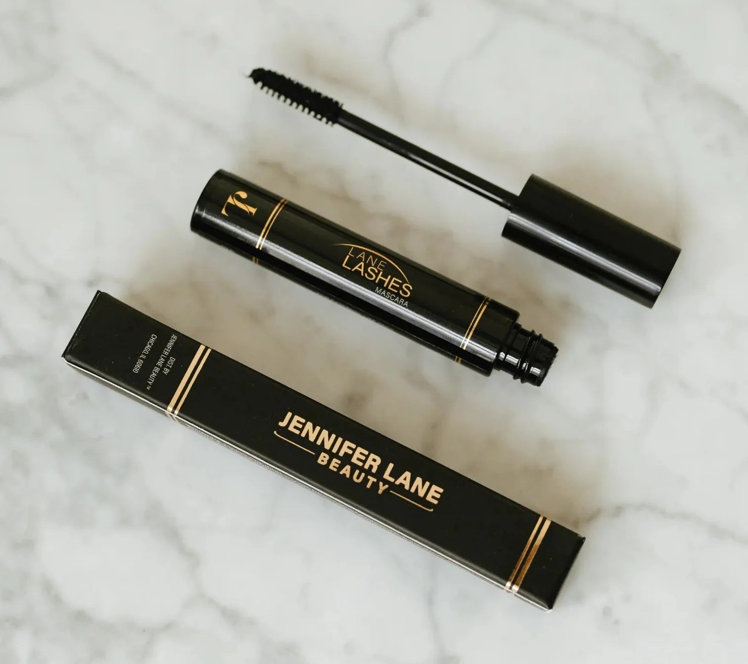 Jennifer Lane Beauty's Lane Lashes mascara on a white marble surface